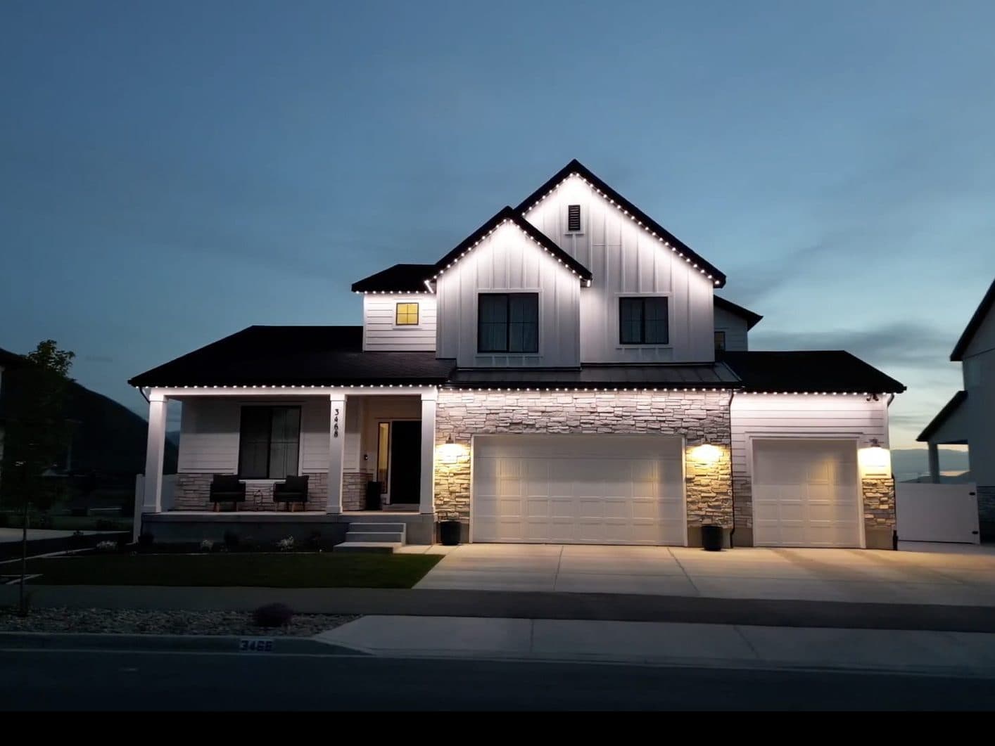 Modern farmhouse in Oswego, IL with permanent exterior lighting along the roofline at twilight