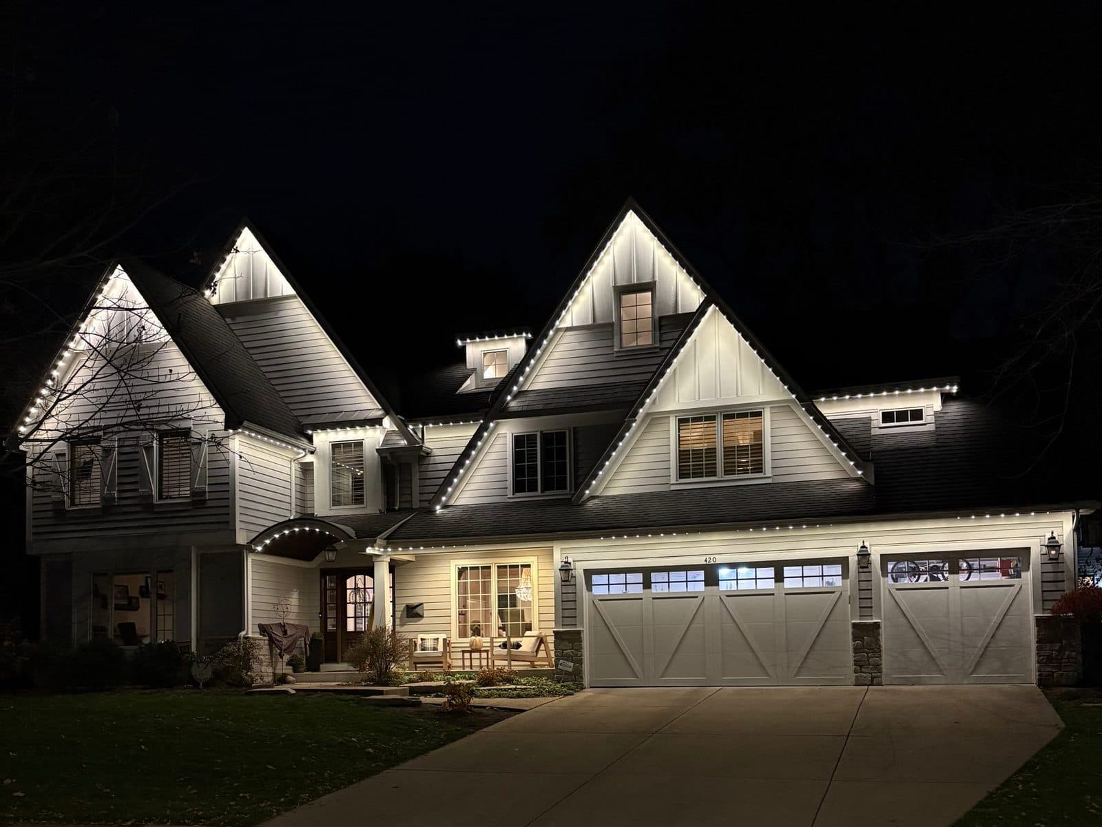 Multi-gable farmhouse in Naperville, IL with permanent roofline lighting installed across every peak