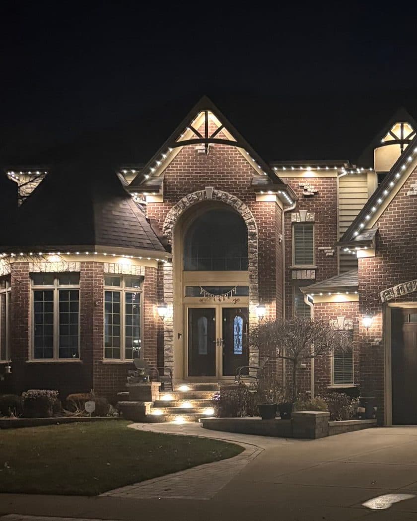 Brick colonial home in Naperville, IL with permanent lighting outlining an arched entryway