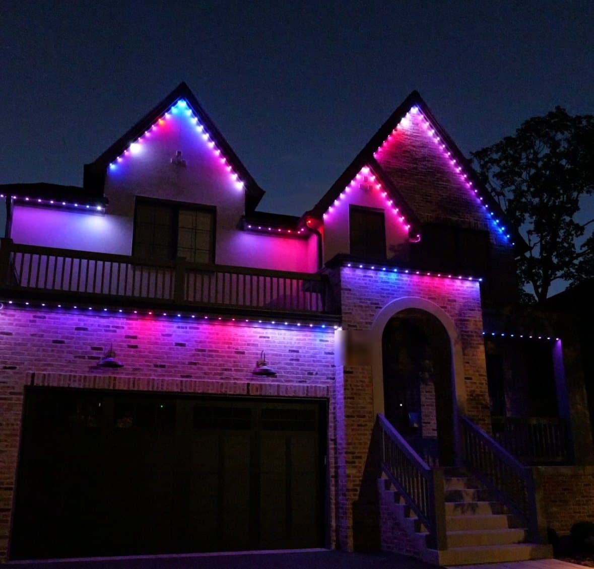The full front of the Naperville English Tudor running a bright color scene on the permanent roofline lighting